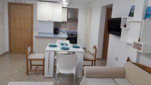 a small kitchen with a white table and chairs at Apartment in LTI Mahdia Beach Hotel in Mahdia