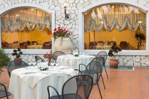 een eetkamer met tafels en stoelen met bloemen erop bij Yellow Park Hotel in Forchia