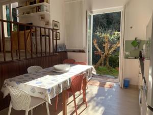 ein Esszimmer mit einem Tisch, Stühlen und einer Tür in der Unterkunft La Cicala, Tellaro in Tellaro