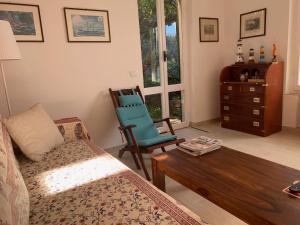 ein Wohnzimmer mit einem Sofa und einem Stuhl in der Unterkunft La Cicala, Tellaro in Tellaro
