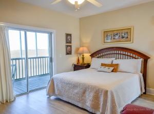 a bedroom with a bed and a sliding glass door at The Sunset Inn in Sunset Beach