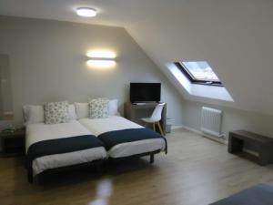 a bedroom with a bed with a desk and a window at Hotel Alda Estación Pontevedra in Pontevedra