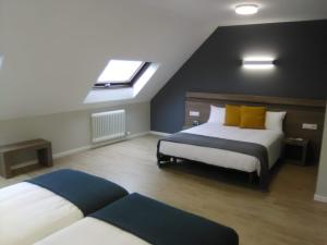 a bedroom with two beds and a skylight at Hotel Alda Estación Pontevedra in Pontevedra