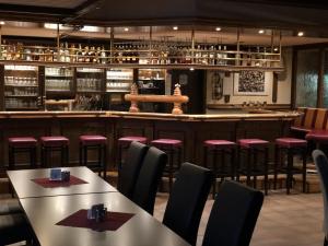 a restaurant with tables and chairs and a bar at Hotel Zur Post in Haren