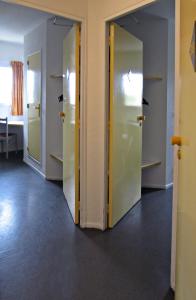 un couloir avec trois portes dans une chambre dans l'établissement Hôtel Noctuel Blois Sud, à Saint-Gervais-la-Forêt