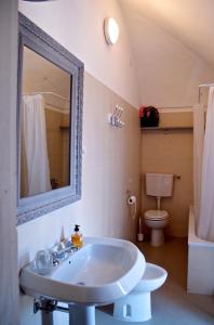 a bathroom with a sink and a toilet and a mirror at Palazzina Rosa in Lanciano