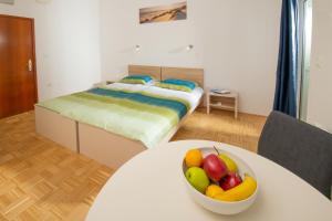 een slaapkamer met een bed en een fruitschaal op een tafel bij Marta in Fažana