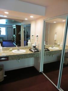 a bathroom with two sinks and a large mirror at Saddle West Casino Hotel in Pahrump