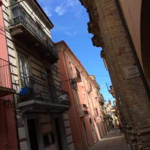ランチャーノにあるPalazzina Rosaの青空を背景にした二棟の間の路地