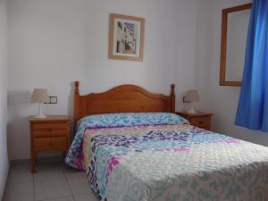 ein Schlafzimmer mit einem Bett und zwei Nachttischen mit Lampen in der Unterkunft Alquileres Cap y Corp in Alcossebre + 36 Fotos