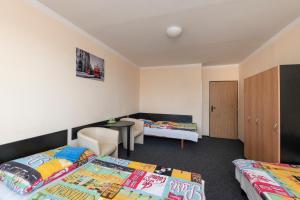 a bedroom with two beds and a desk and a chair at Hotel Buly in Písek