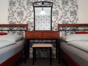 ヴィシュシー・ブロトにあるPenzion Romanceのベッドルーム1室(ベッド2台、鏡付きドレッサー付)