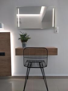 a black chair sitting in front of a mirror at Aestas Apartments in Agia Marina Nea Kydonias