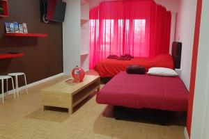 1 dormitorio con cama roja y mesa en Apartamento Adargoma tipo loft, en Vecindario
