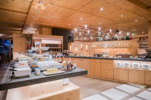 a large kitchen with wooden cabinets and a counter at Post Alpina - Family Mountain Chalets in San Candido