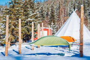 a tent and a teepee in the snow at Fińska Wioska Kalevala in Borowice