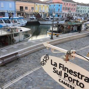 una señal para un puerto deportivo con barcos en el agua en La Finestra sul Porto, en Cesenatico