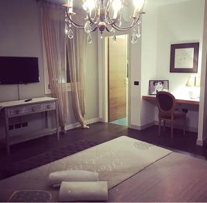 a living room with a chandelier and a table and a desk at La Finestra sul Porto in Cesenatico +20 photos