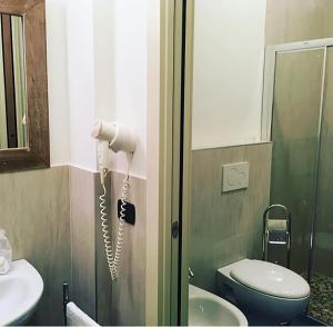 bagno con servizi igienici e telefono appeso al muro di La Finestra sul Porto a Cesenatico