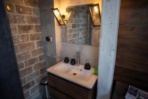 a bathroom with a sink and a brick wall at Vysoka Khata 5 in Lviv