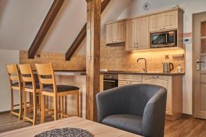 kuchnia z drewnianymi szafkami, stołem i krzesłami w obiekcie Apartmán Barborka 07 Horní Malá Úpa w mieście Horní Malá Úpa