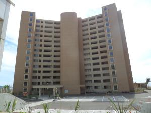 un gran edificio bronceado con muchas ventanas en Departamento En Arena Maris, en Algarrobo