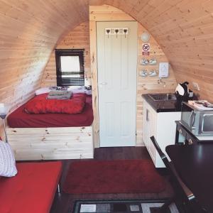 a room with a bed and a kitchen in a cabin at Spinning Wheel Pod in Dunvegan