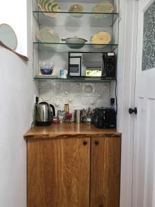 eine Küche mit einem Holzschrank mit Geschirr auf einem Regal in der Unterkunft The Ceramic House in Brighton & Hove