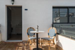 2 sillas y una mesa en el patio en Cicerone de Sevilla, en Sevilla