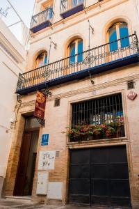 un edificio con un balcón con flores. en Cicerone de Sevilla, en Sevilla