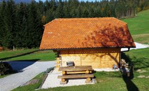 eine kleine Blockhütte mit einem Tisch und einem Dach in der Unterkunft Apartments Jasa in Mozirje