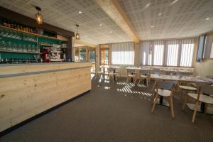 a restaurant with tables and chairs and a bar at Hôtel Le Chamois d'Or, USSIM Vacances Méribel in Méribel