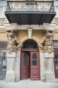 a building with two statues on the front of it at Atlant Hotel in Tbilisi City