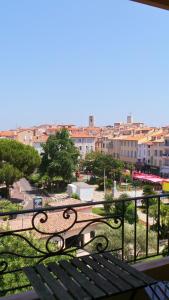 a park bench with a view of a city at Hotel Relais Du Postillon in Antibes