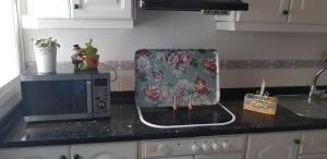 a microwave sitting on a kitchen counter next to a sink at Apartamento frente a Palacio de Congresos (Fibes) in Seville