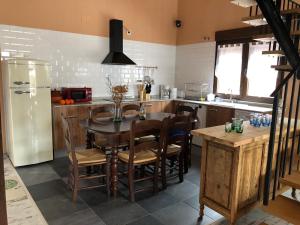 a kitchen with a table and chairs and a refrigerator at La Salceda in Torre Val de San Pedro