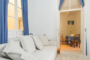 a living room with a white couch and a table at OlhãOmirante Guesthouse in Olhão