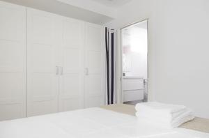 a white bedroom with a shower and a bed at BALENTZIAGA Getaria in Getaria