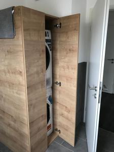 a laundry room with a washer and dryer behind a wooden closet at FEWO Klosterblick sowie Weinberge & Drachenflieger in Zeltingen-Rachtig