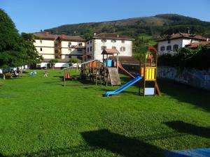 a playground with a slide in a grass field at Apartamento Usuaia con jacuzzi in Lesaka