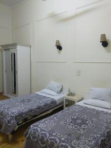 zwei Betten, die in einem Zimmer nebeneinander stehen in der Unterkunft De La Poste in Port Said + 24 Fotos