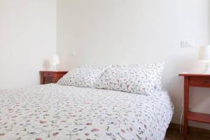 una camera da letto con un letto con un copriletto floreale e due tavoli di LAURINA COZY SPANISH STEPS AREA a Roma