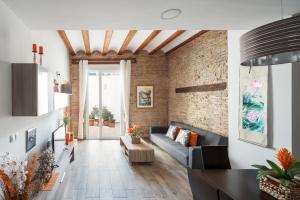 a living room with a couch and a brick wall at Flats Piera Valencia Center in Valencia