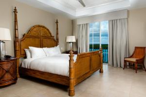 a bedroom with a bed and a large window at Blue Haven Resort- All Inclusive in Grace Bay