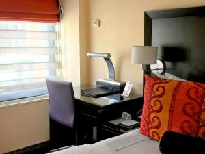 a bedroom with a desk with a lamp and a bed at Washington Plaza Hotel in Washington, D.C.