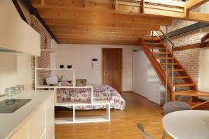 a room with a bed and a spiral staircase at Loft Mirano Due (Alloggi alla Campana) in Mirano