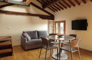 a living room with a couch and a table and chairs at Loft Mirano Due (Alloggi alla Campana) in Mirano