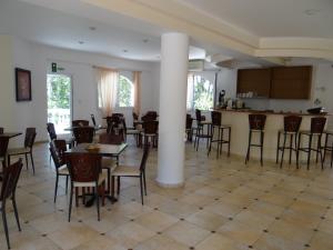 a large room with tables and chairs and a kitchen at Perla Beach in Agia Marina Nea Kydonias
