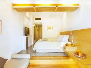 Hotel Europa Olympia في أوليمبيا: غرفة نوم بسرير وطاولة عليها فاكهة