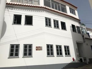 biały budynek z czarnymi oknami w obiekcie Casa Mia w mieście Monchique